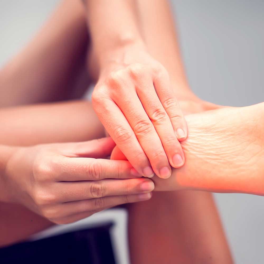 Woman hand holding foot with pain