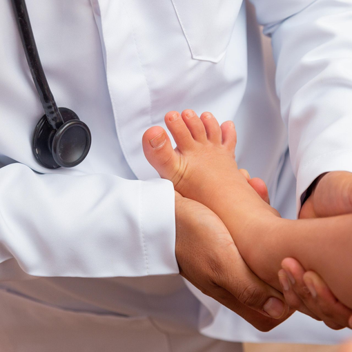 Doctor holding a baby’s feet during a medical exam