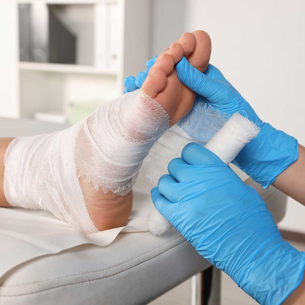 Doctor applying bandage onto patient's foot 