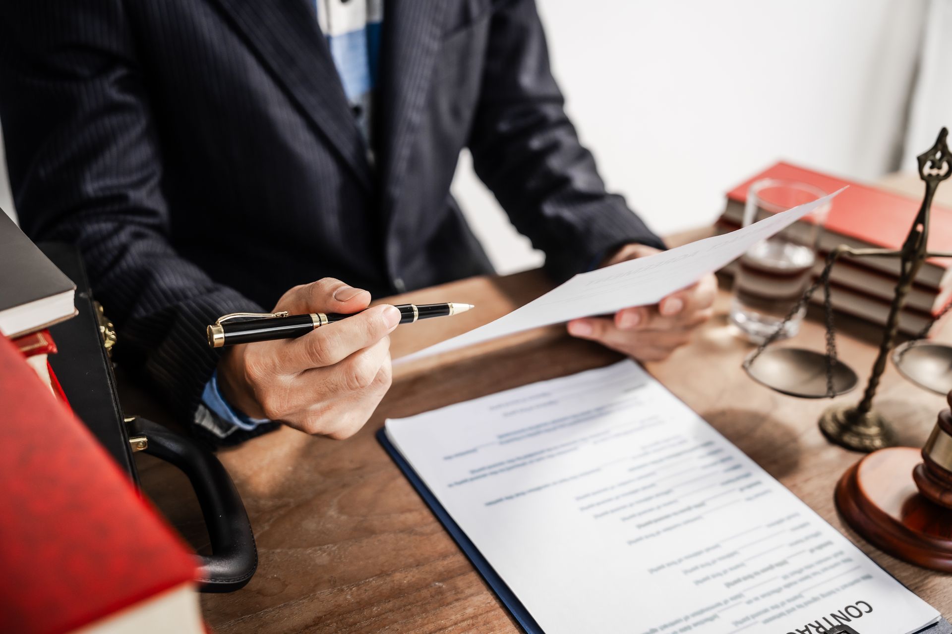 Lawyer reviewing documents at a desk with gavel and stacked legal books