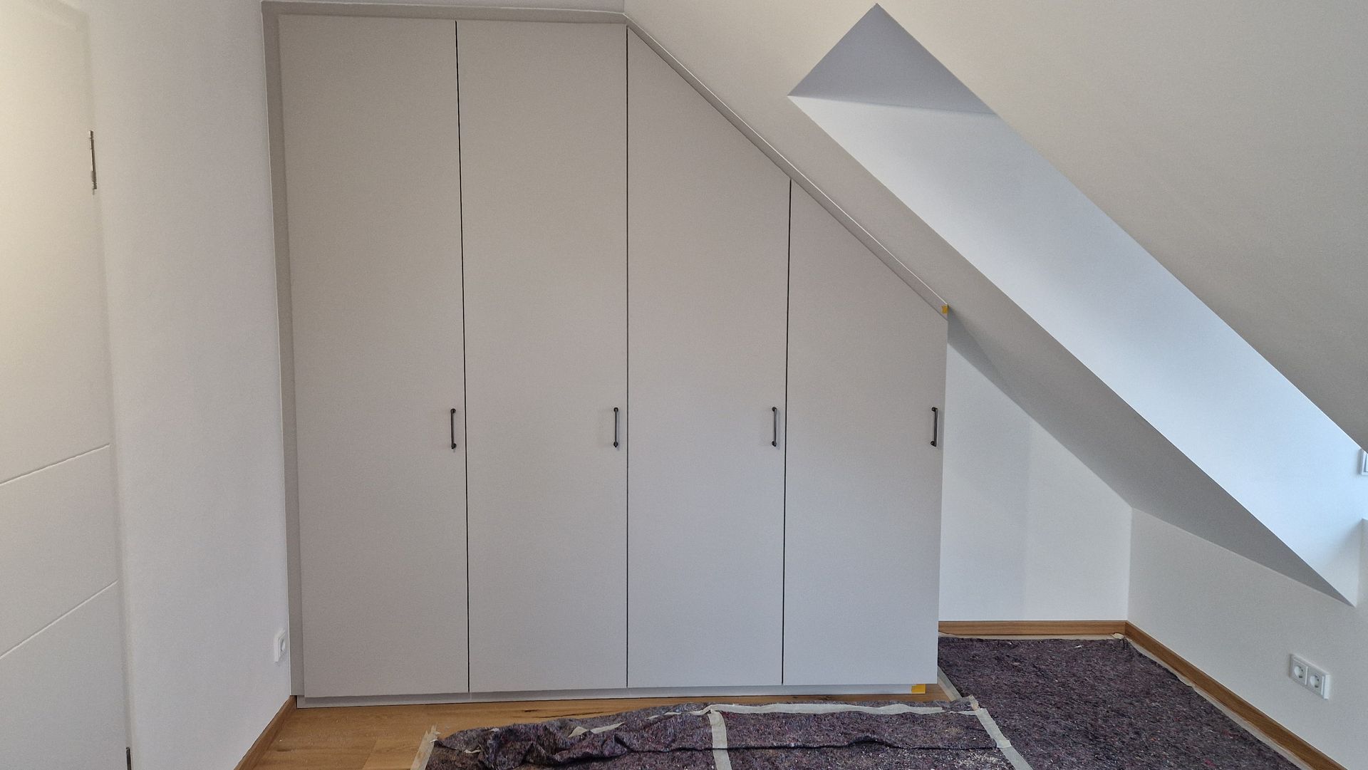 Kleiderschrank aus Holz in der Dachschräge.