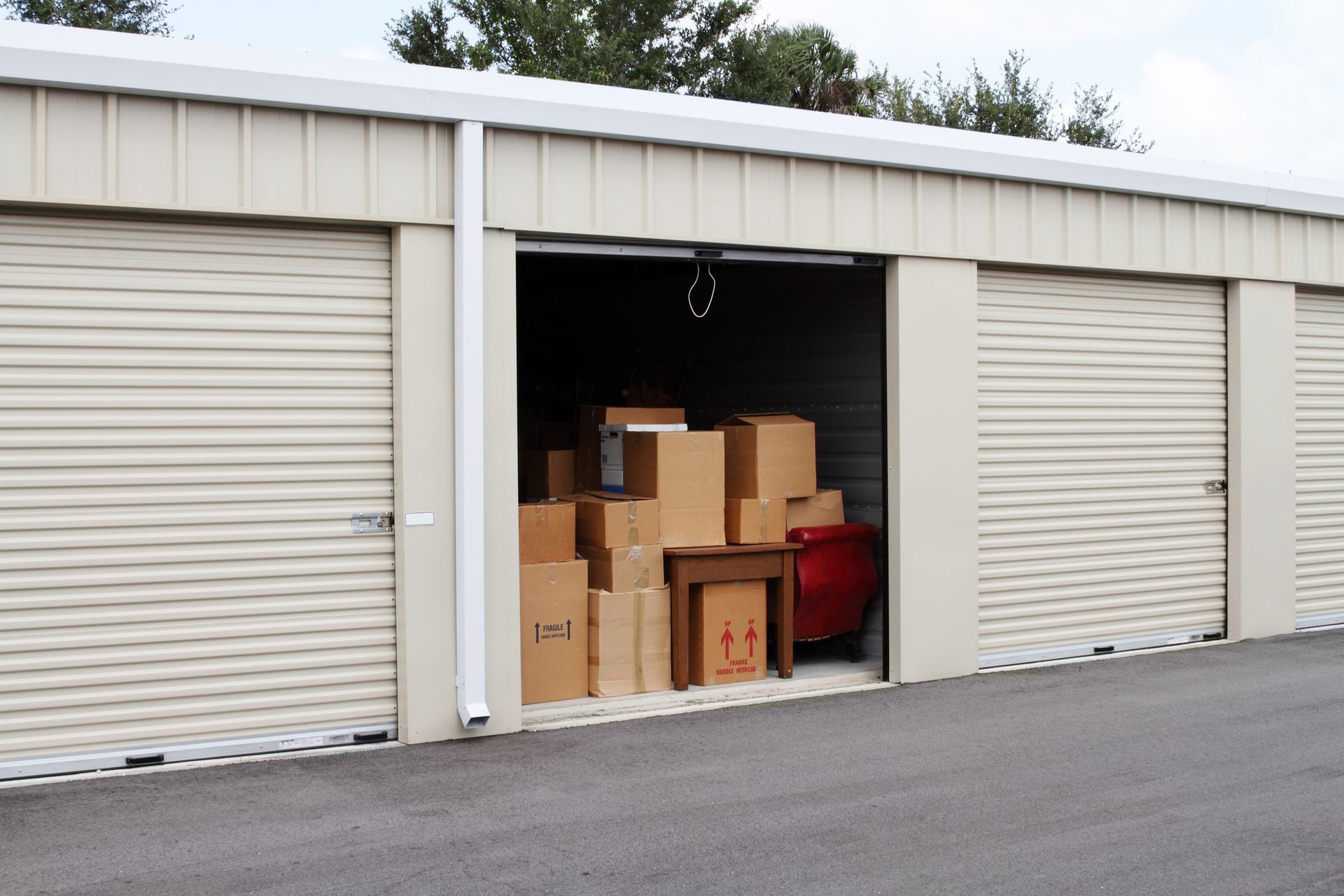 Open storage unit filled with cardboard boxes and small furniture items.