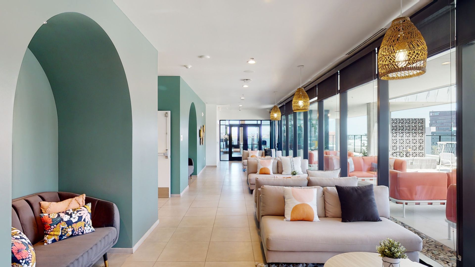 A long hallway with a couch and chairs in it.