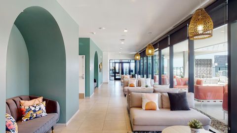 A long hallway with a couch and chairs in it.