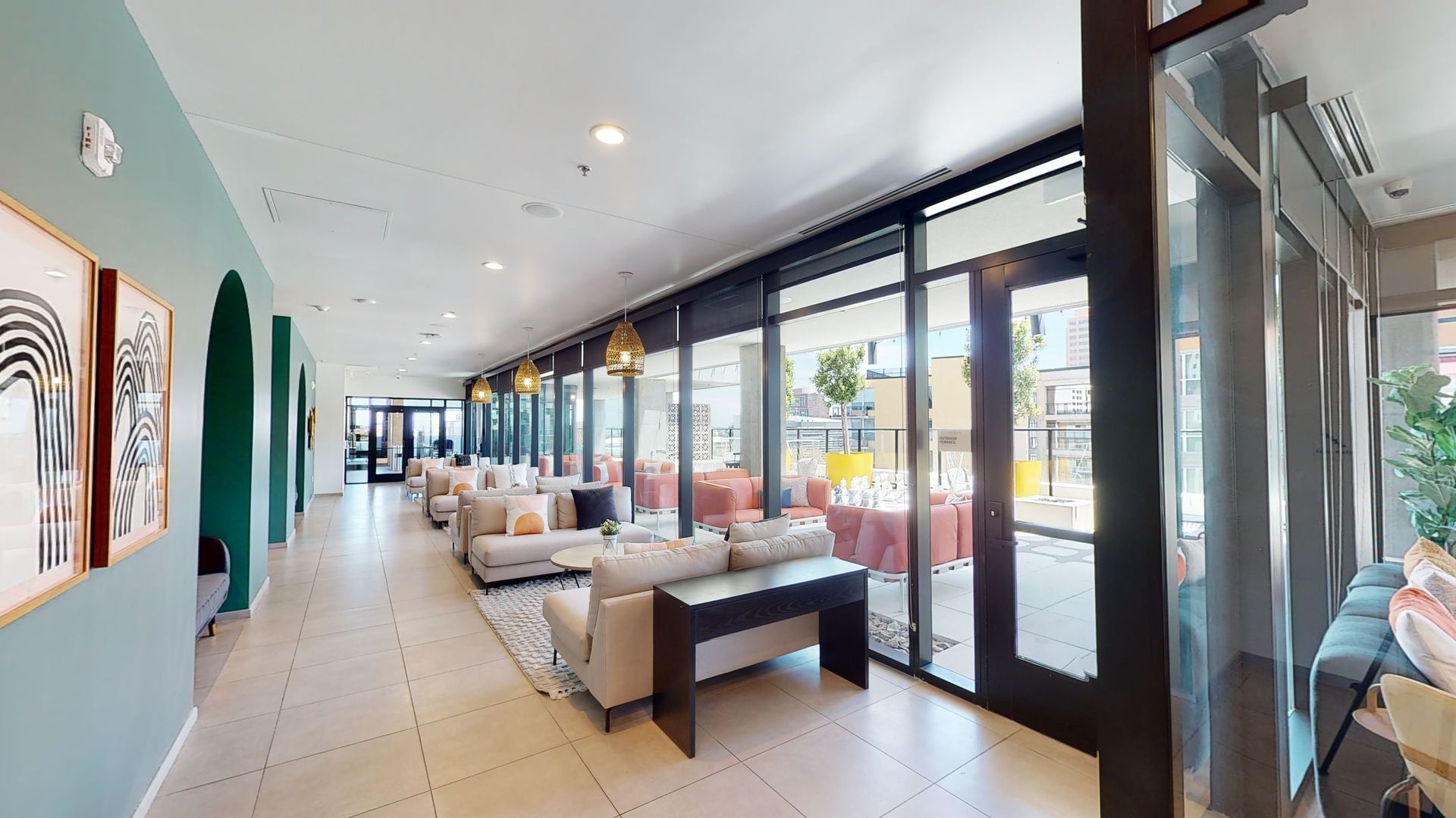A long hallway with a lot of windows and couch.