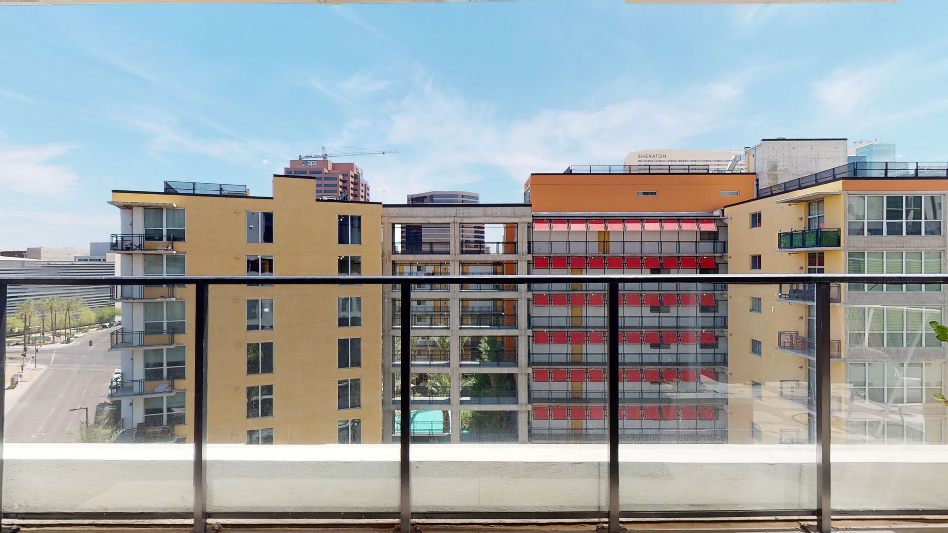 A balcony with a view of a city with buildings in the background.