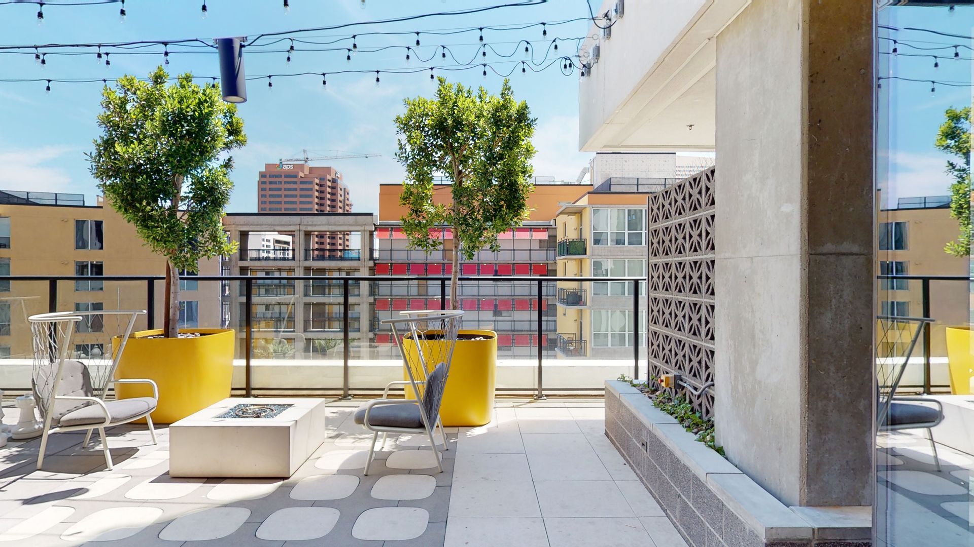 A rooftop patio with a fire pit and trees