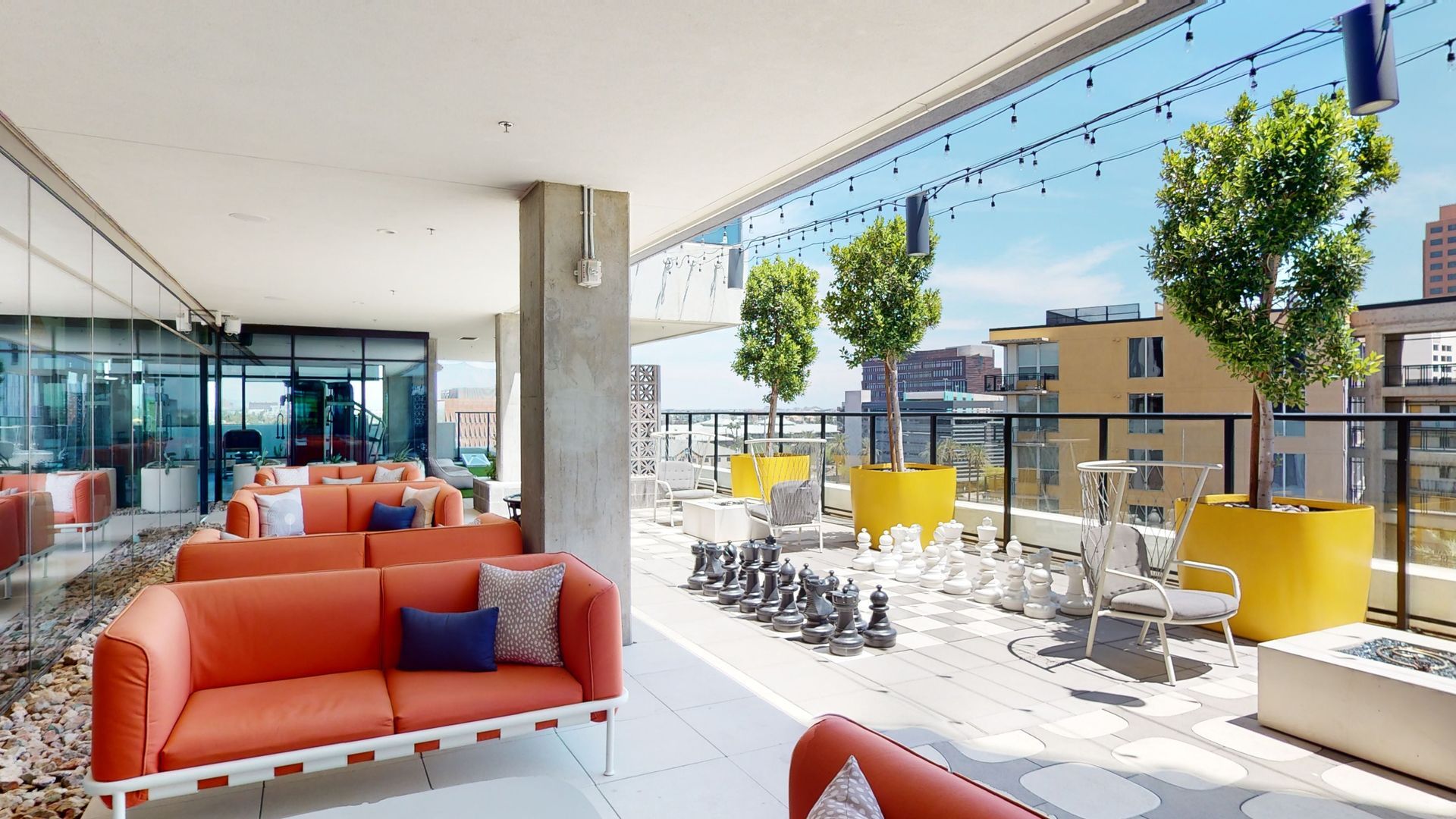 A balcony with a couch , chairs , and chess pieces.