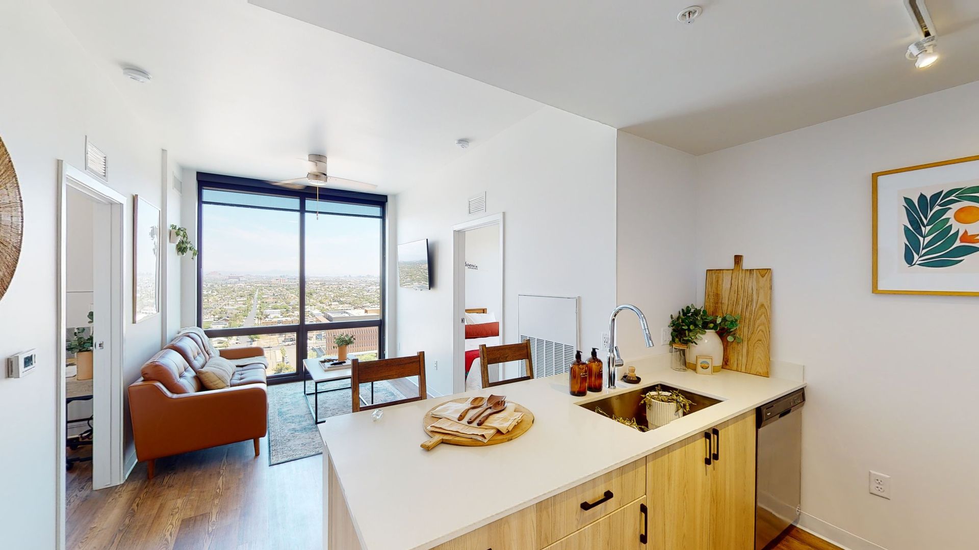 A kitchen with a sink , cabinets , and a large window.