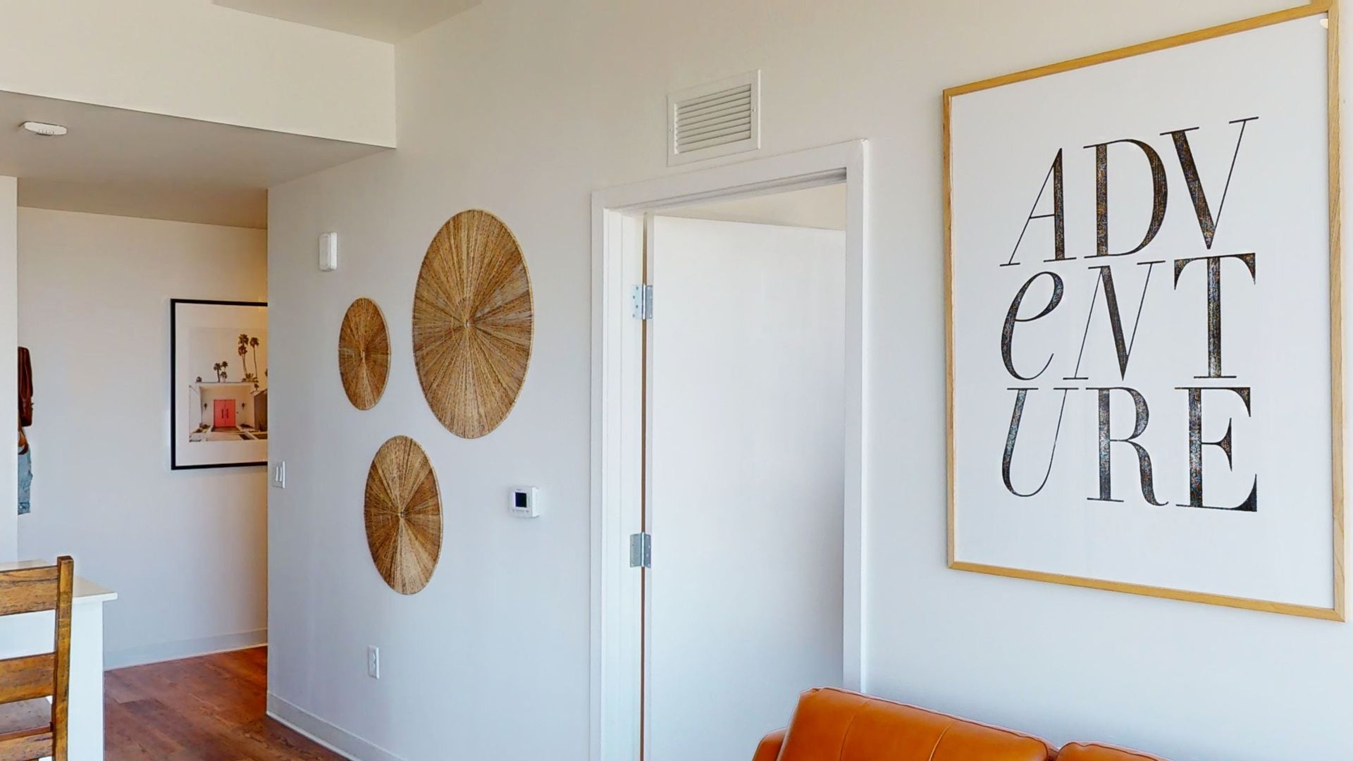 A living room with a couch and a sign that says adventure