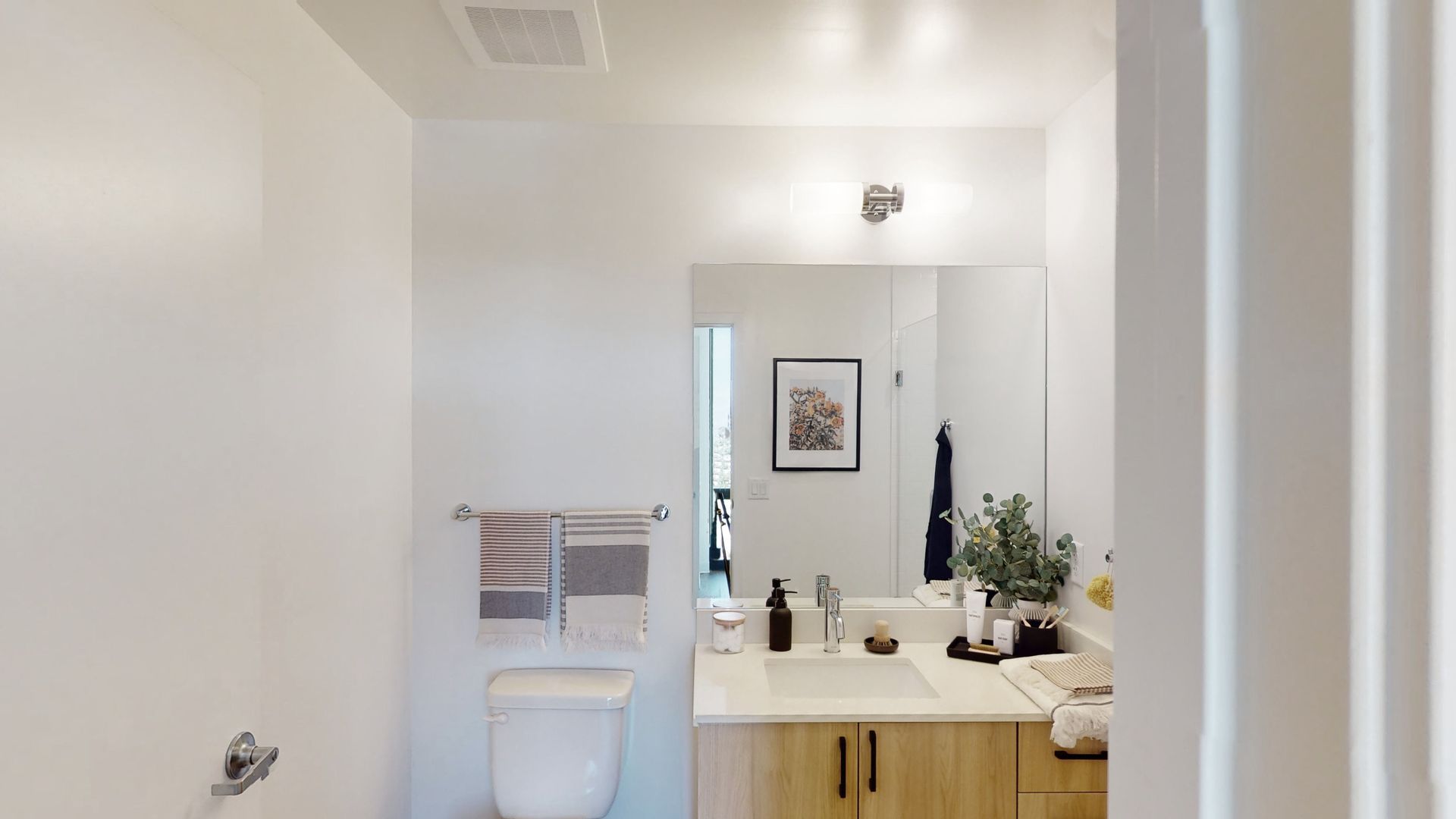 A bathroom with a sink , toilet and mirror.