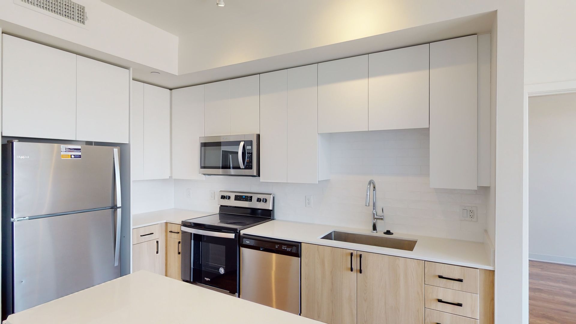 A kitchen with stainless steel appliances and white cabinets.