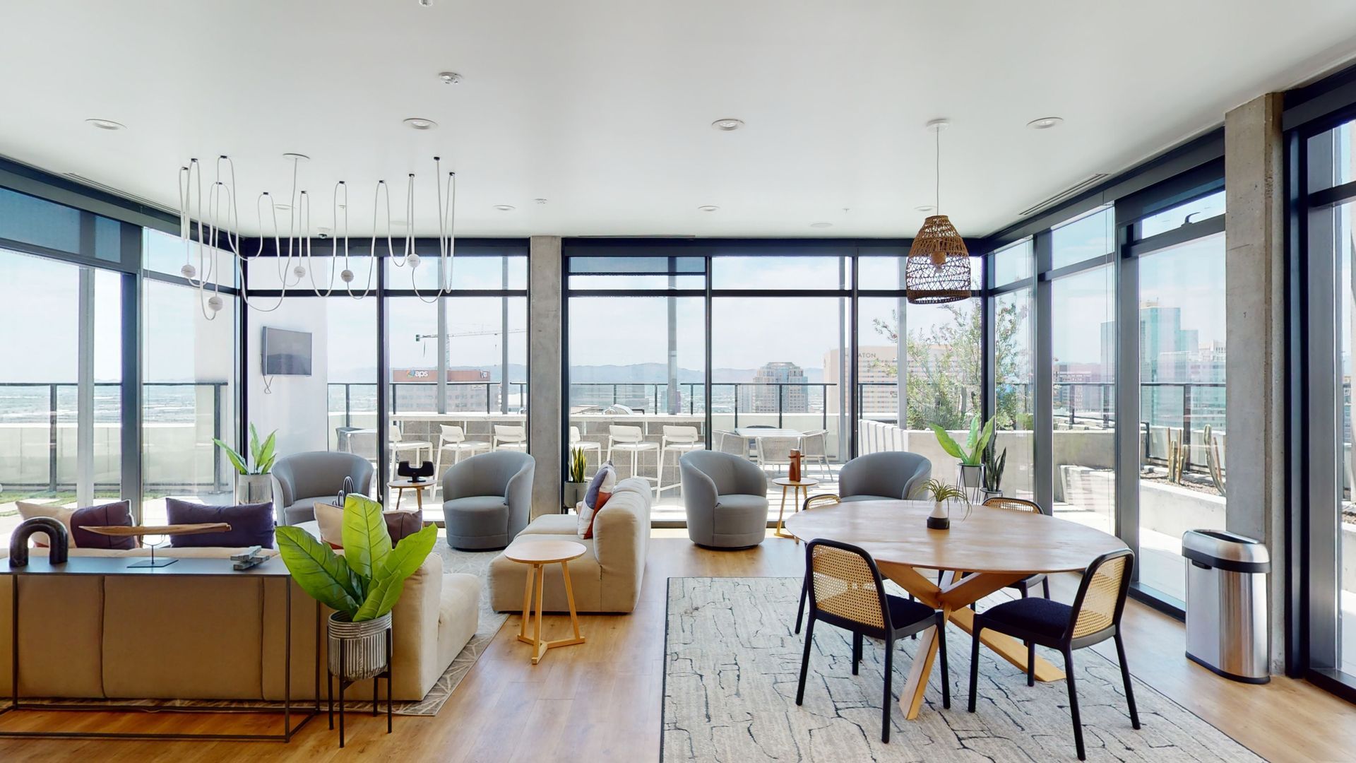 A living room with a table and chairs and a lot of windows.