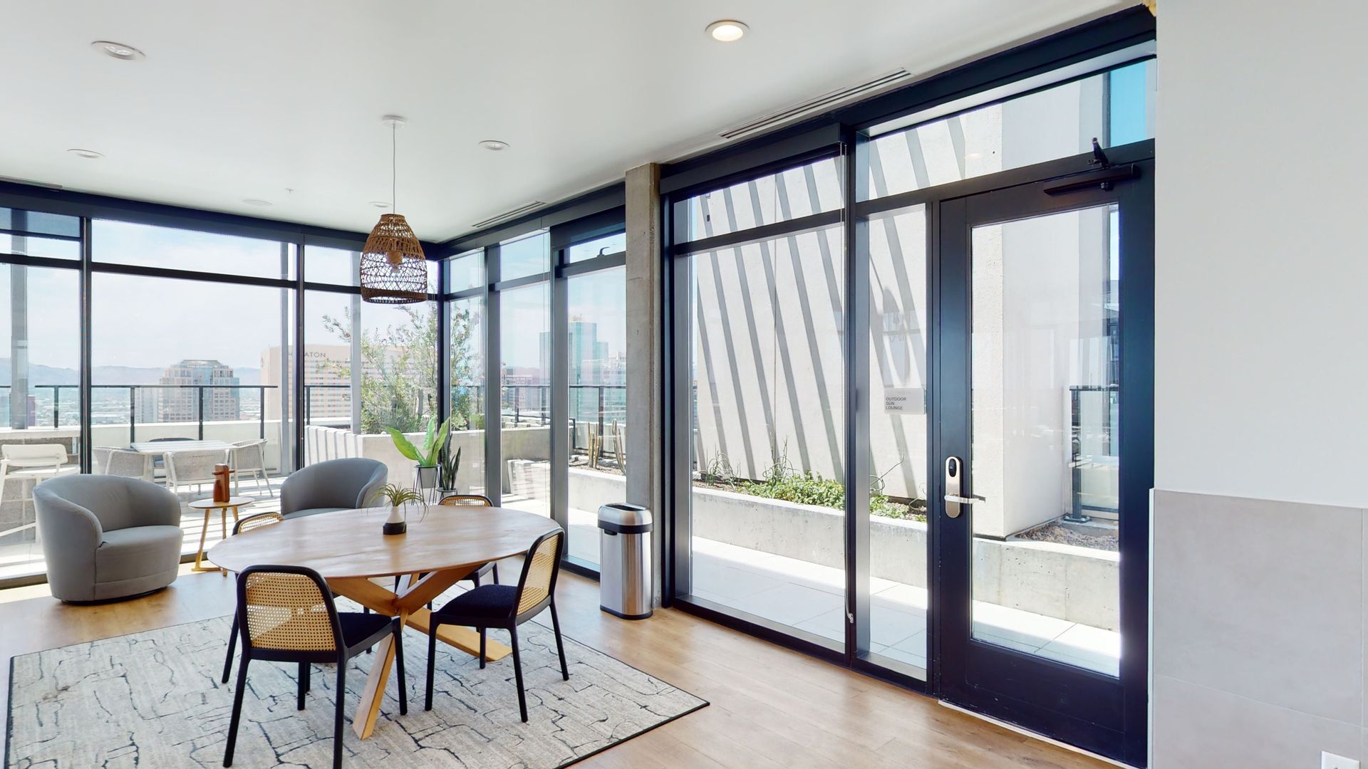 A living room with a table and chairs and a lot of windows.