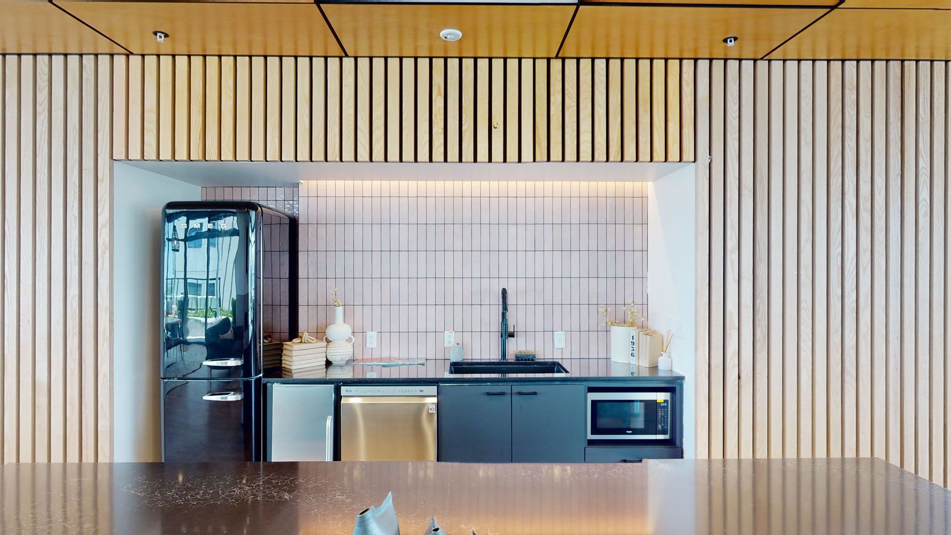 A kitchen with a refrigerator , sink , microwave , and dishwasher.