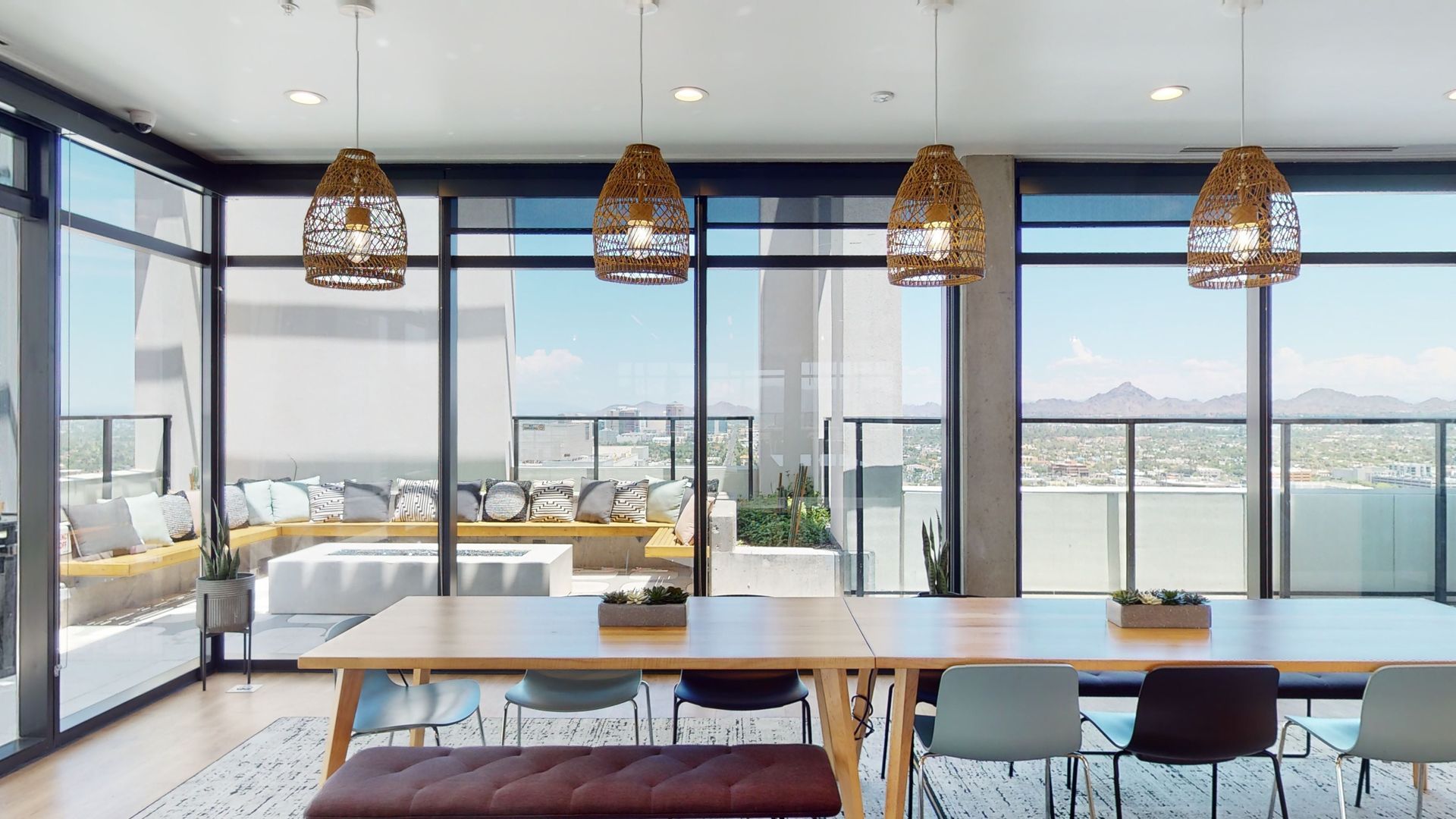 A large room with a table and chairs and lots of windows.