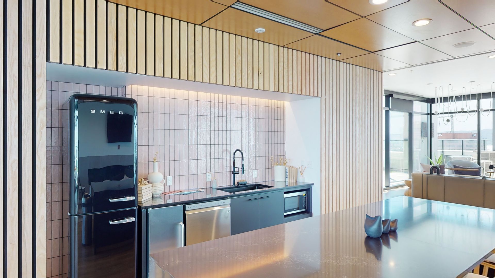 A kitchen with a black refrigerator , sink , and dishwasher.