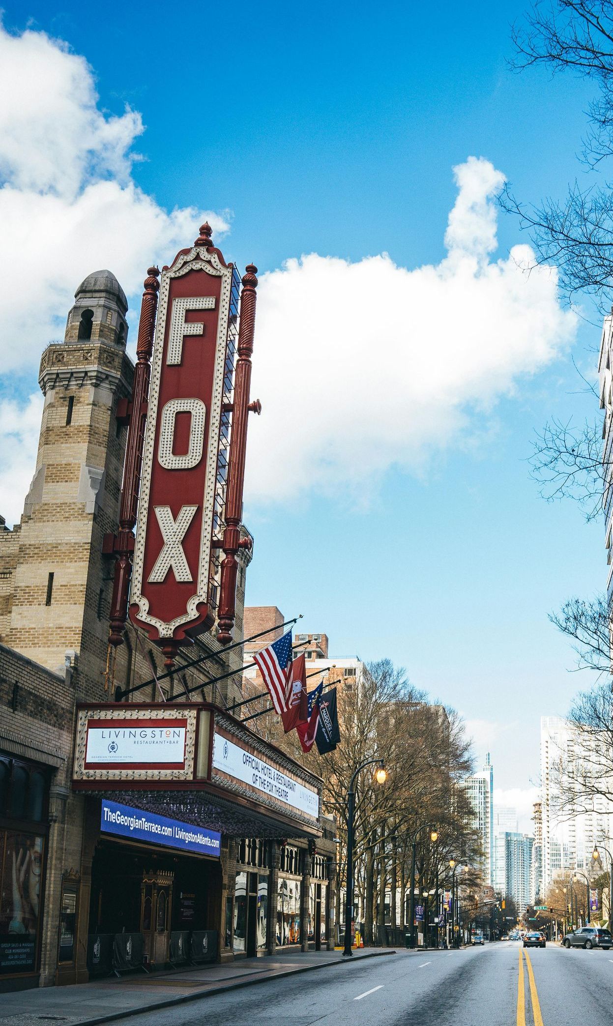 A fox theater is located on the corner of a city street.