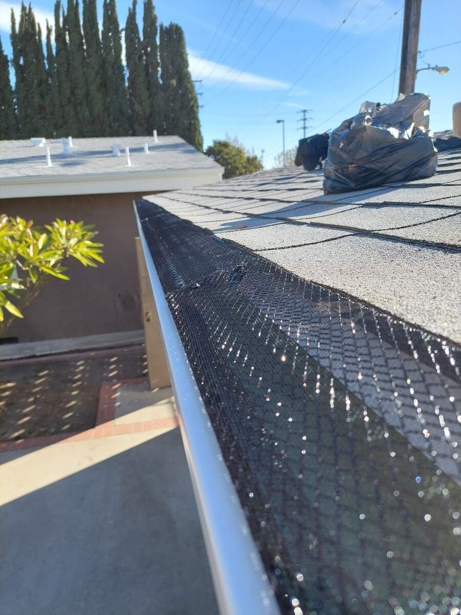 A gutter with a net on it is sitting on top of a roof.