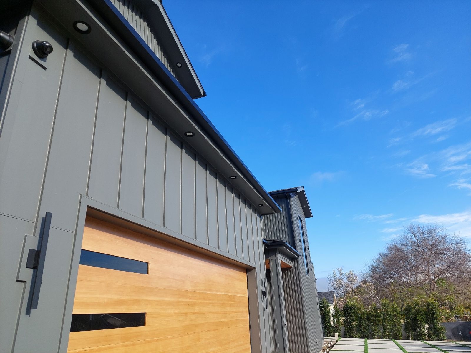 A house with a wooden garage door and a gray siding