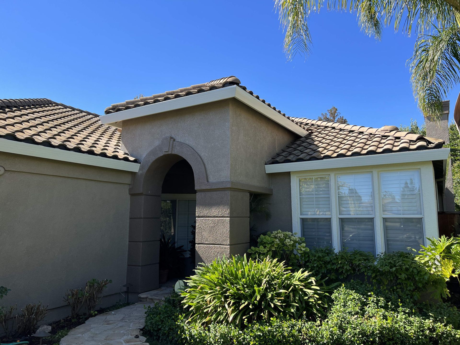 A house with a tiled roof and a walkway leading to it