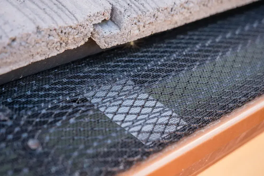 A close up of a metal mesh on a roof.