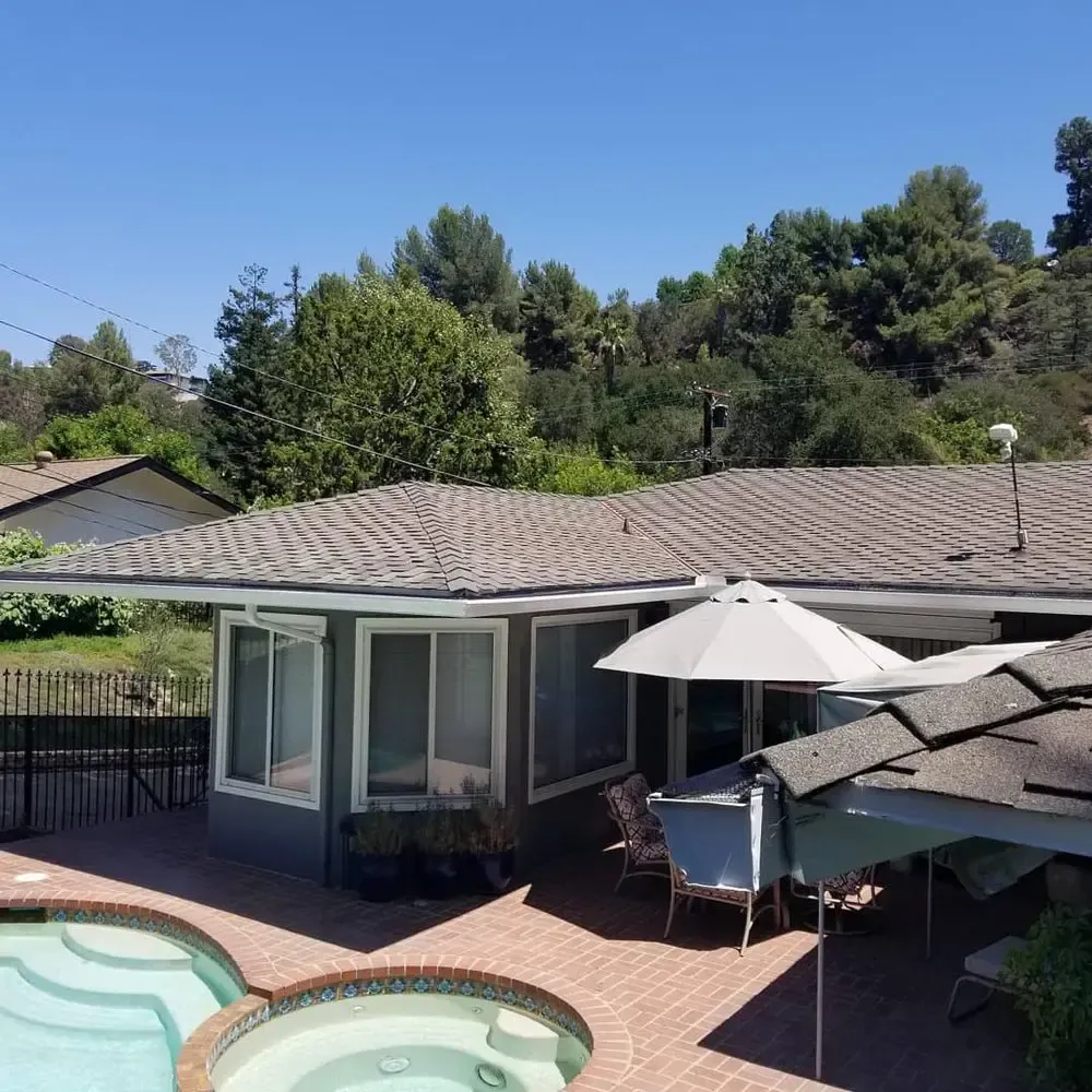 A house with a pool and umbrellas in front of it