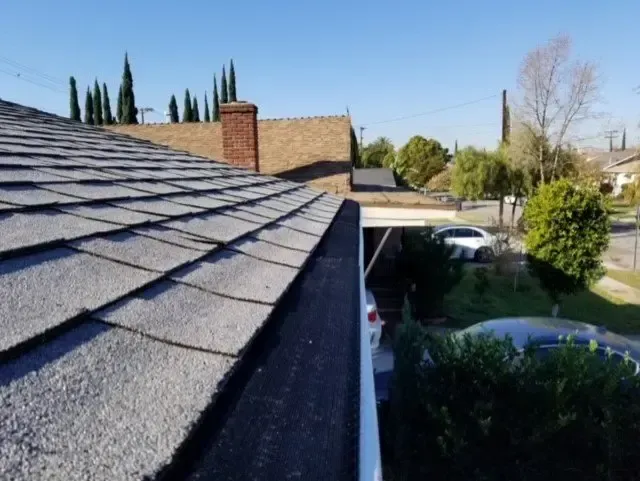 The roof of a house with a car parked underneath it