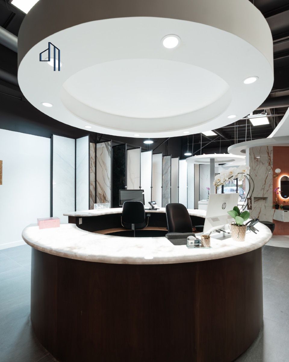 Reception desk with a curved countertop and round overhead lighting.