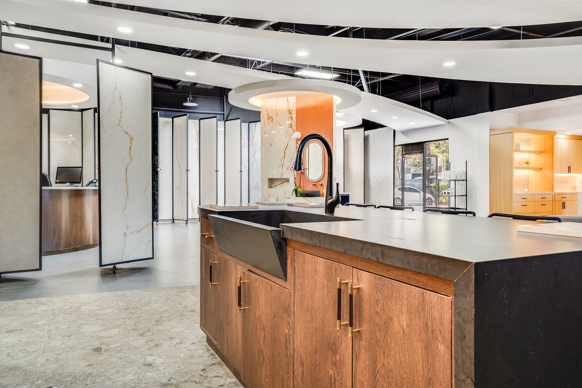 Kitchen showroom with display island, granite countertop, and wood cabinetry.