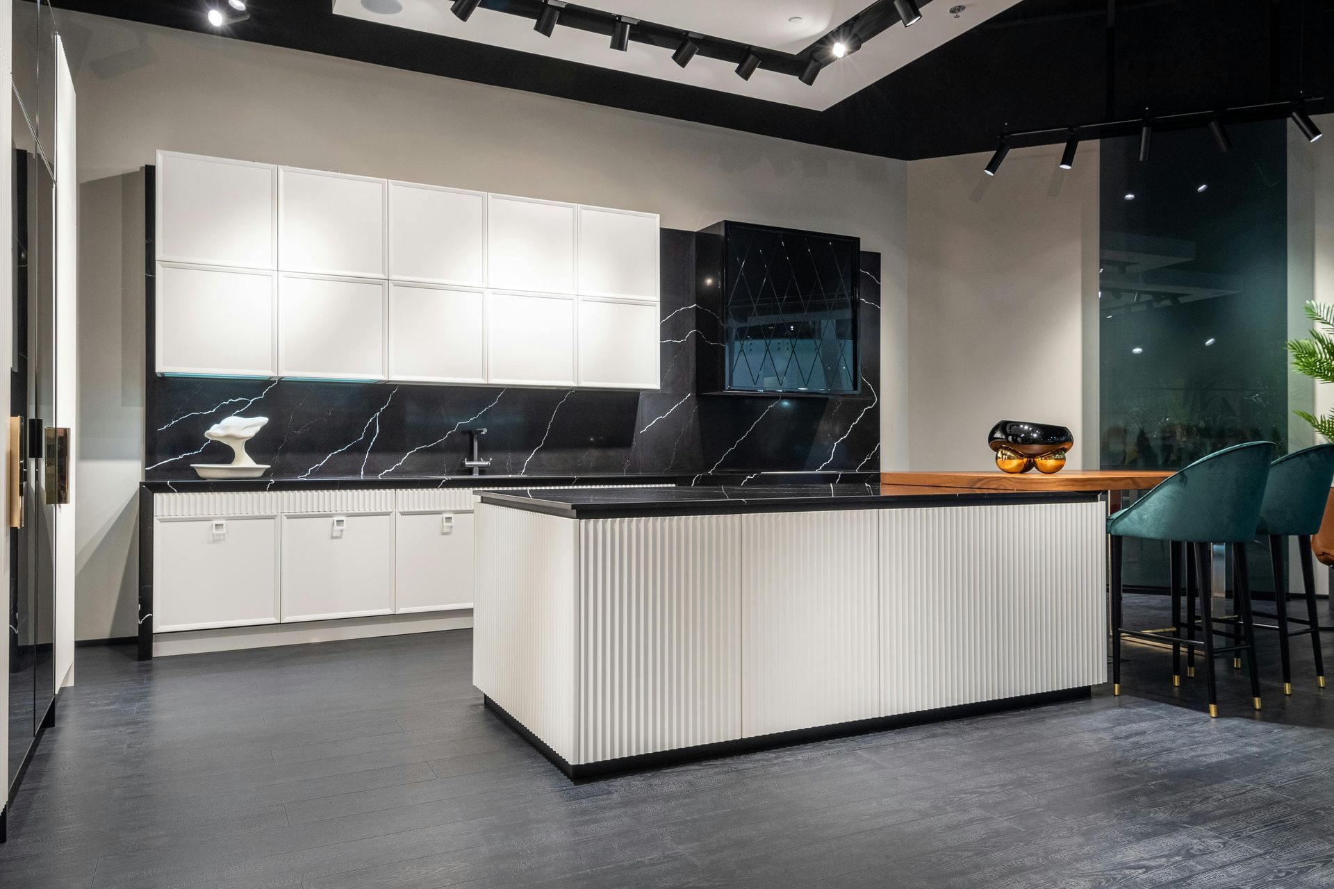 Modern kitchen with white cabinets, black countertops, and a central island.