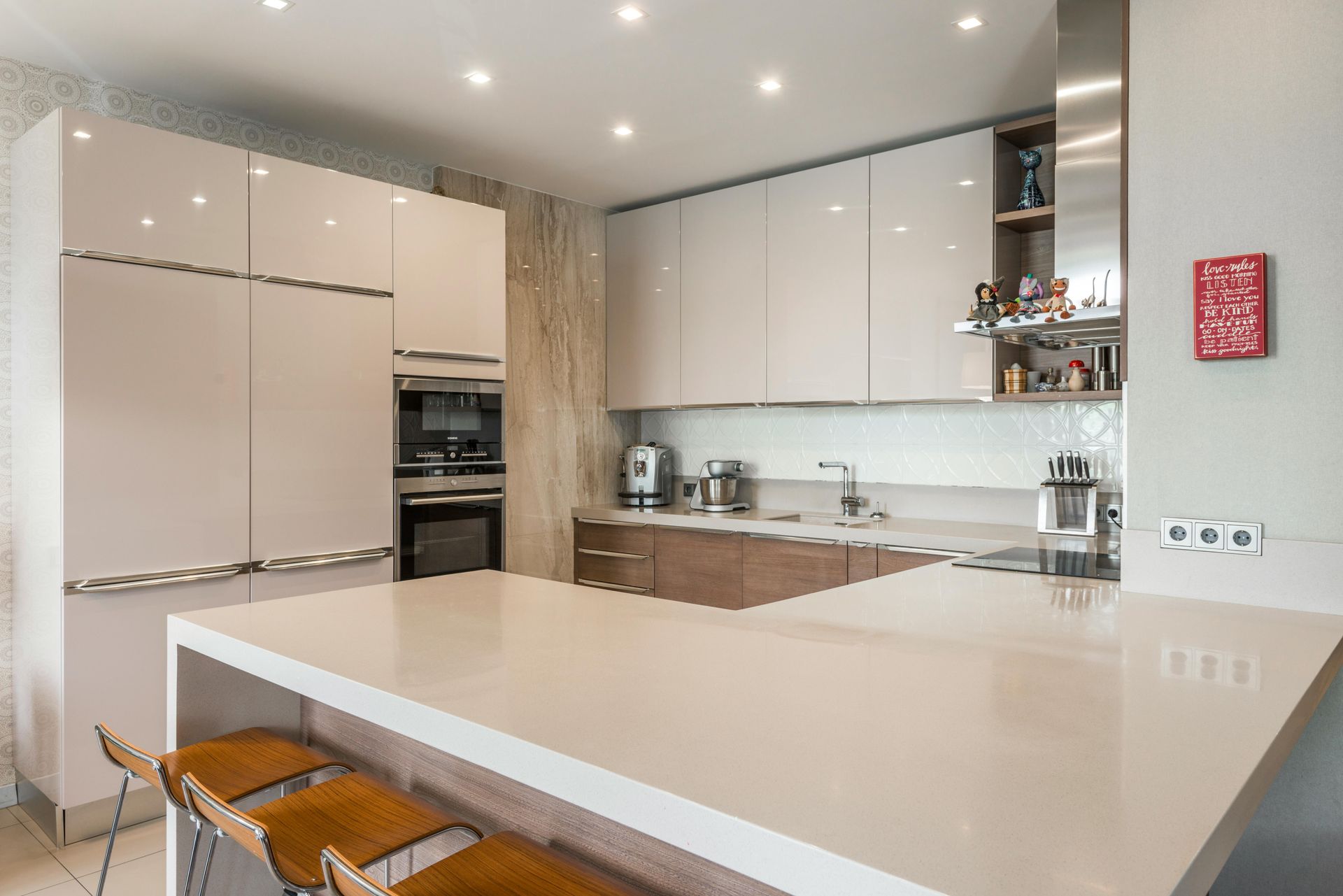 Modern kitchen with white cabinets, island, and brown stools.