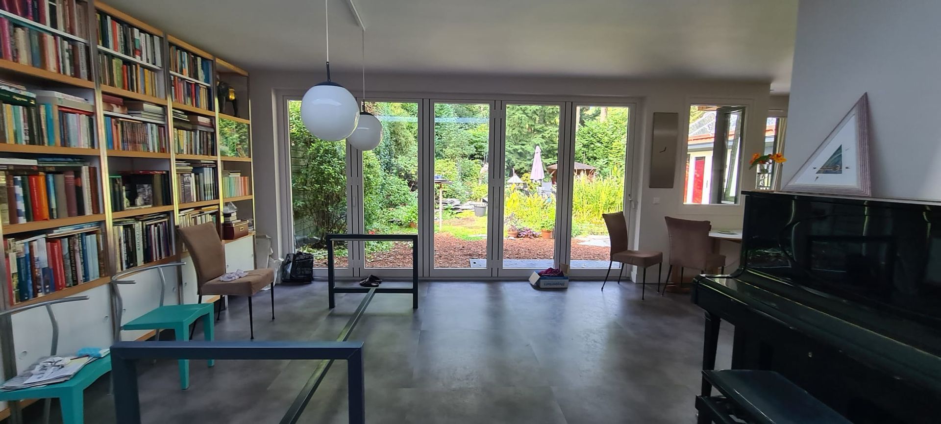 Een woonkamer vol meubels en een piano.