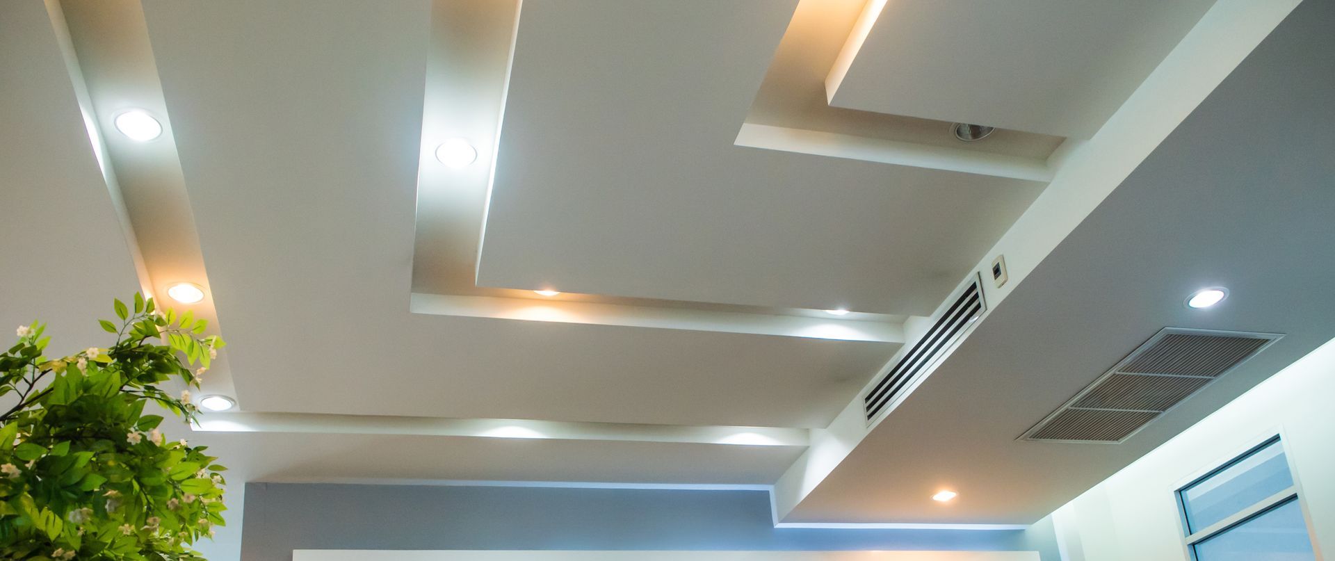 Un salon avec un plafond sur lequel il y a beaucoup de lumières.