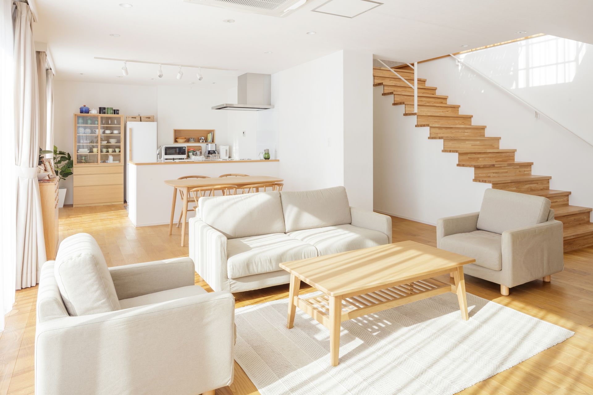 Un salon avec un canapé, des chaises, une table basse et des escaliers.