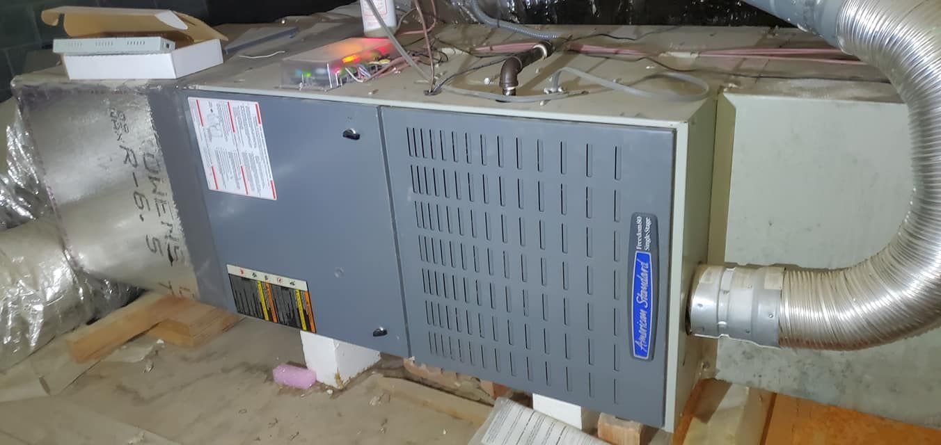 A large air conditioner is sitting on top of a wooden table in a room.
