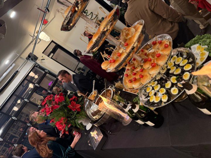 A group of people are gathered around a table full of food