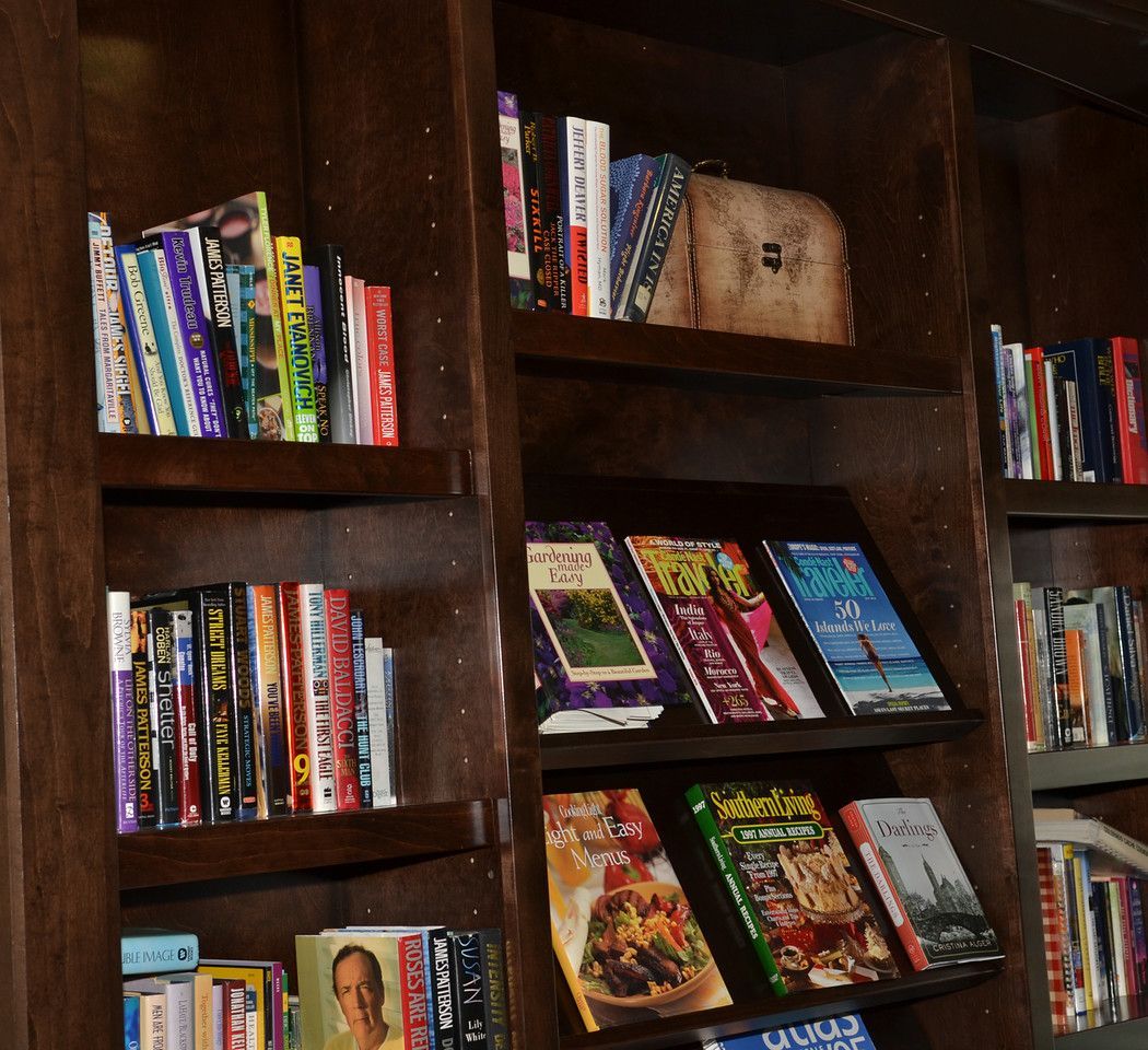 Dark wood built-in bookshelf filled with colorful books and magazines.