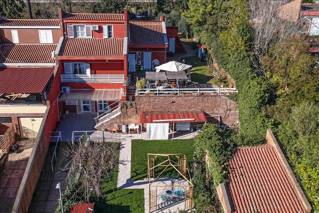 Una vista aerea di una casa con un ampio cortile sul retro