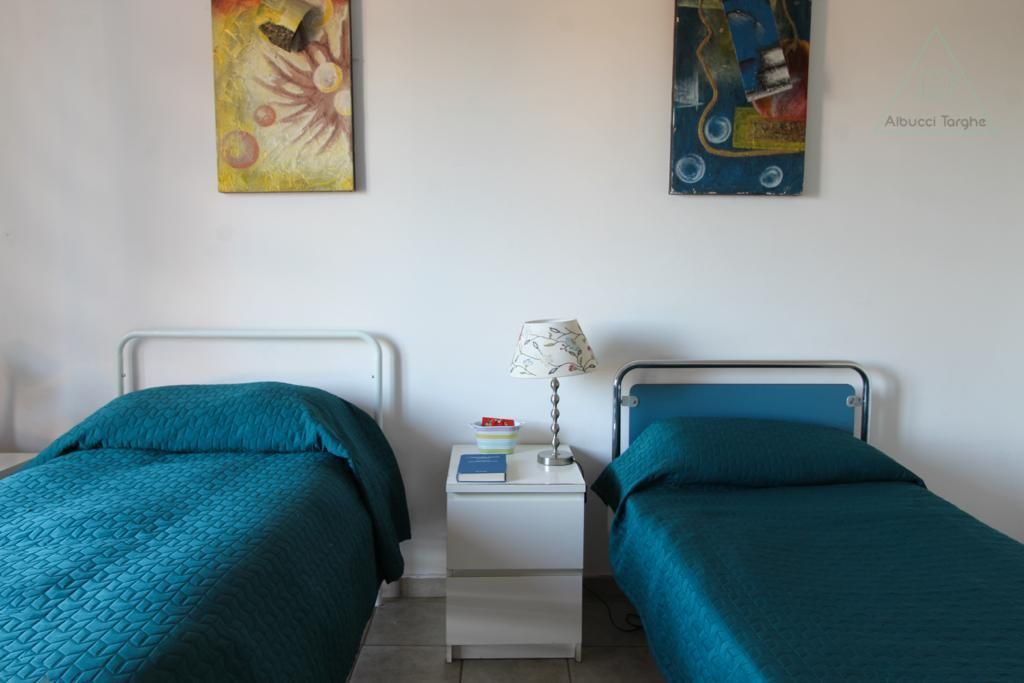 Una camera da letto con due letti e due quadri sul muro