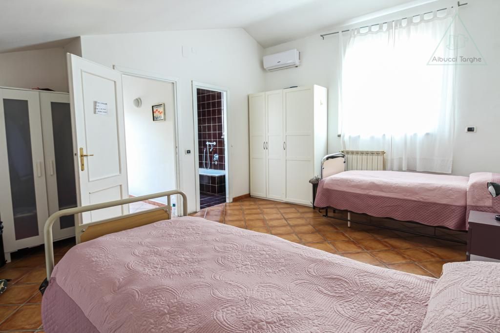 A bedroom with two beds , a dresser , and a window.