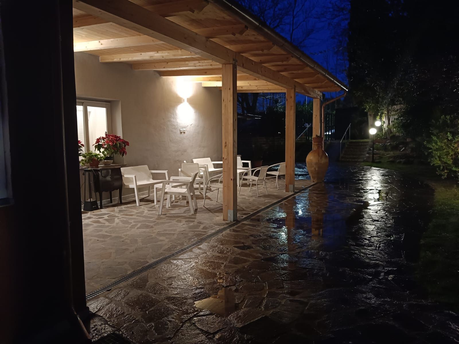 Un patio con tavoli e sedie sotto una tettoia di notte.