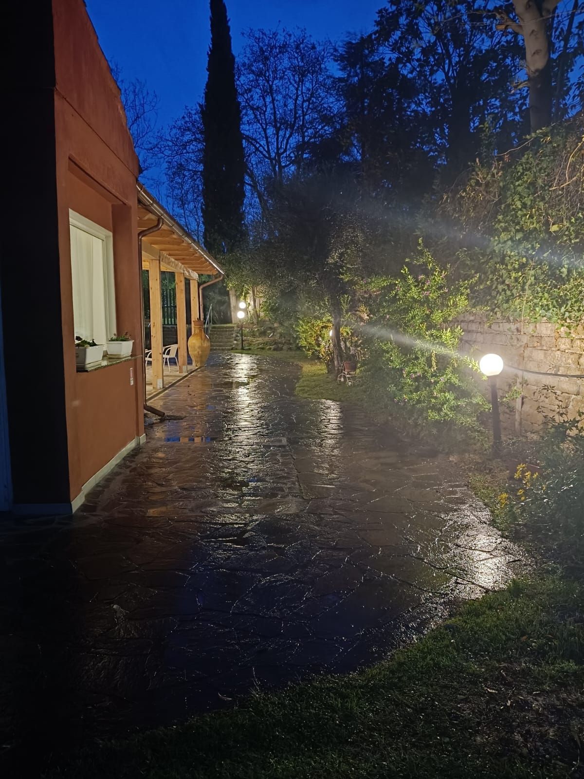 Una casa è illuminata di notte sotto la pioggia.