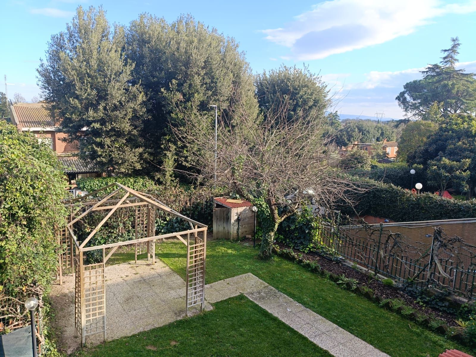 C'è un gazebo in mezzo a un rigoglioso giardino verde.