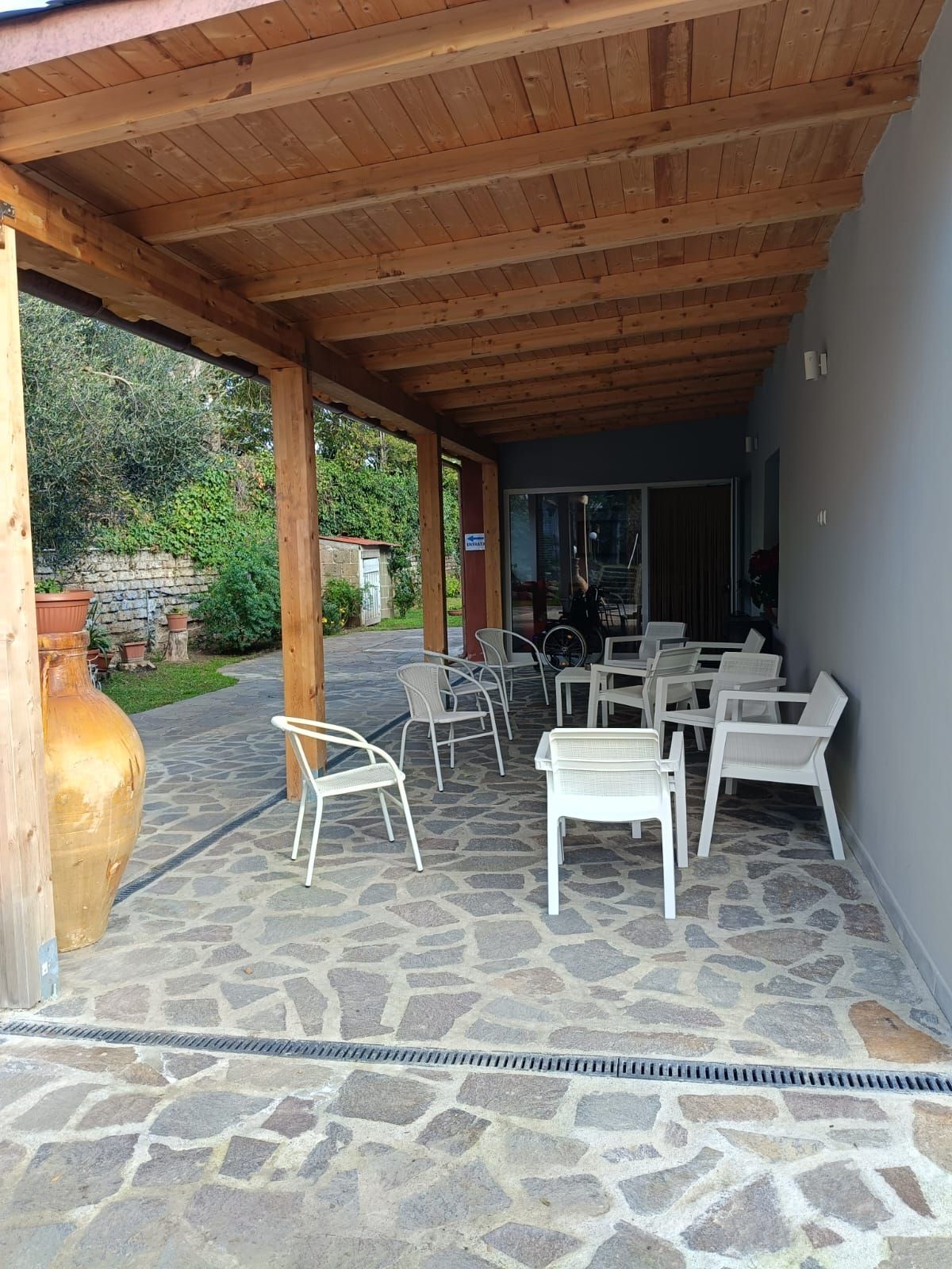 Un patio con sedie e tavoli sotto un tetto in legno