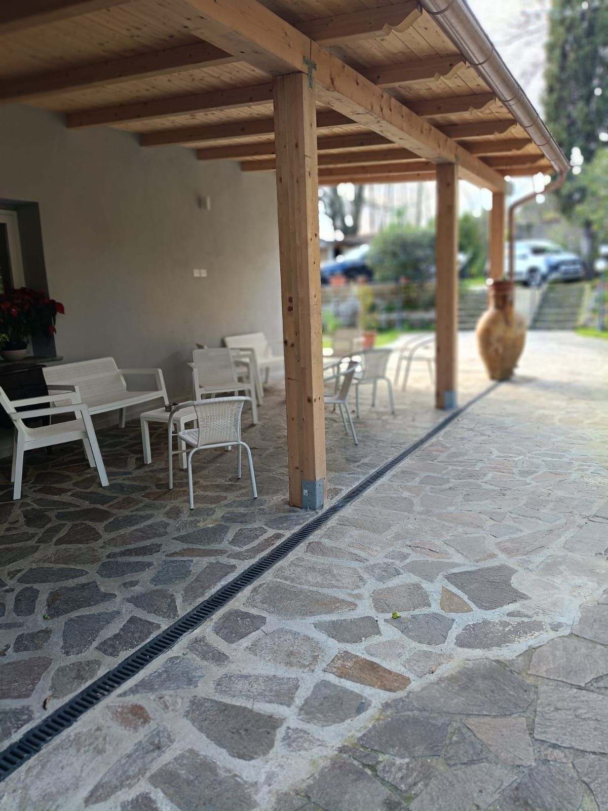 Un patio con sedie e tavoli sotto un tetto in legno
