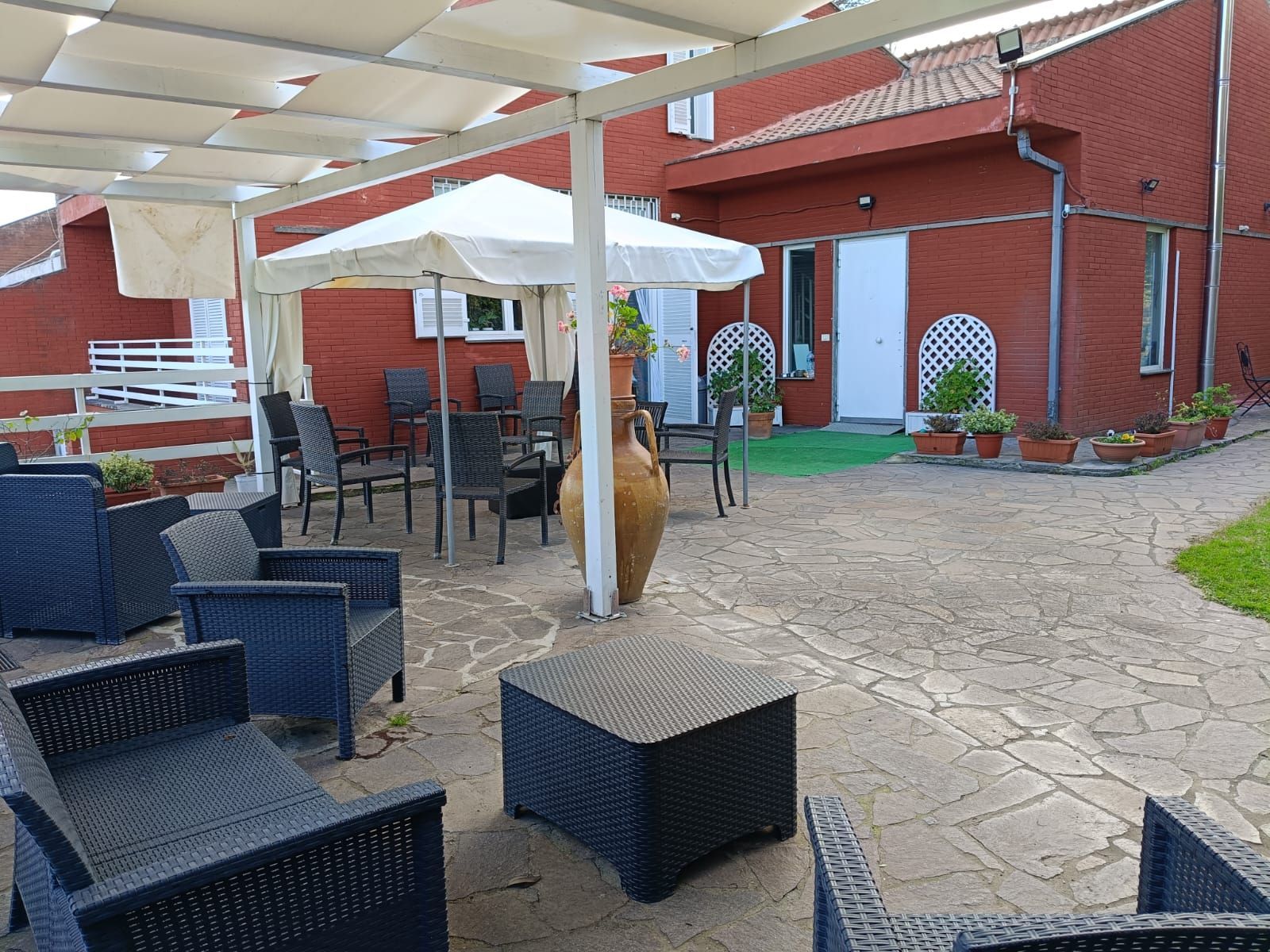 Un patio con sedie e un tavolo sotto una tettoia