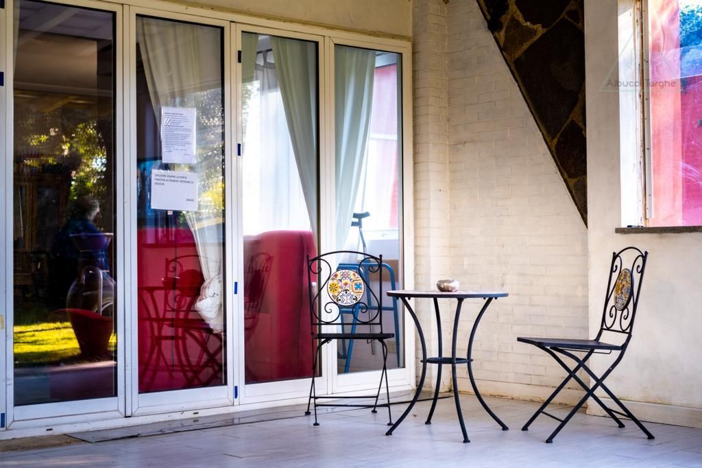 Un patio con tavolo e sedie davanti a una porta a vetri