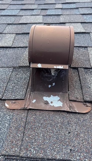 Brown roof vent on asphalt shingles, showing peeling paint and weathering.
