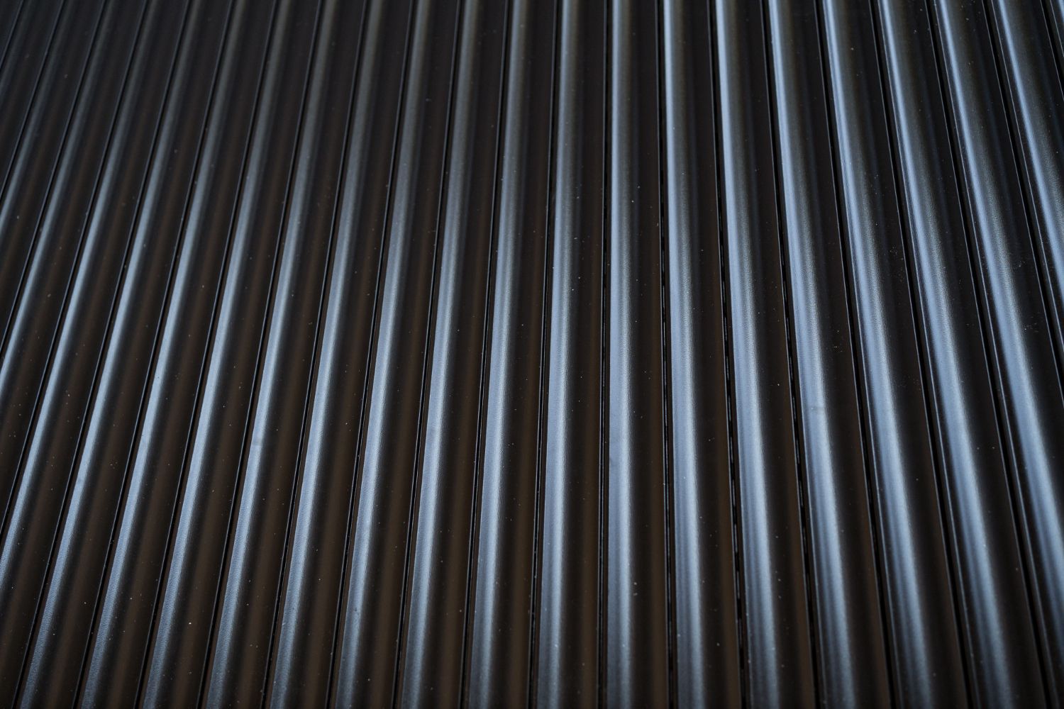A close up of a black corrugated metal wall.